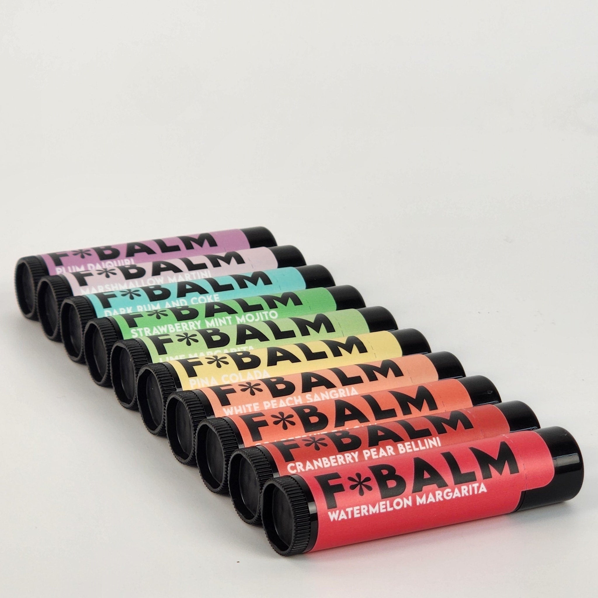 Lip balms in various colors with black caps, F*BALM brand name visible on tubes