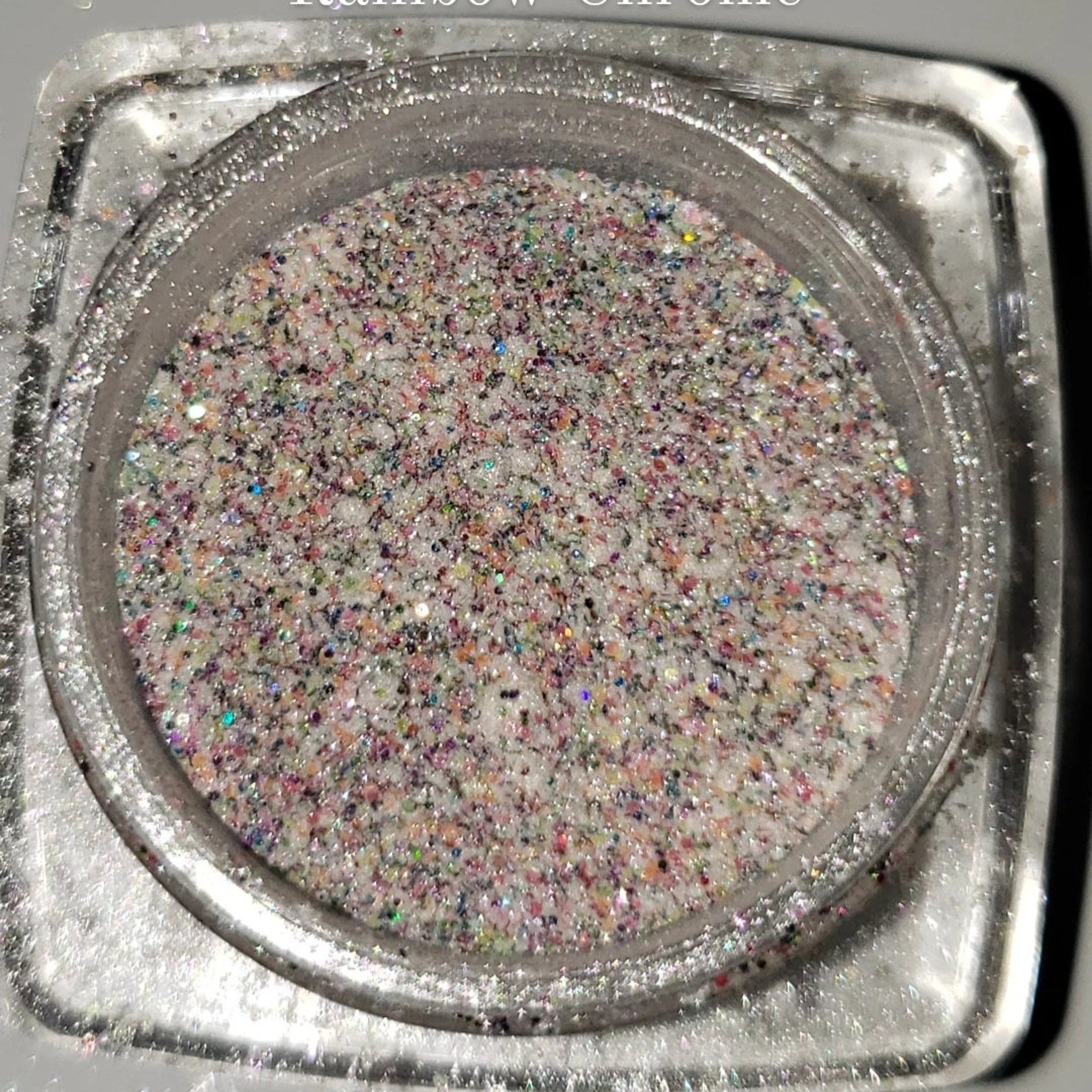 Close-up of shimmering loose glitter eye shadow with sparkling particles catching the light