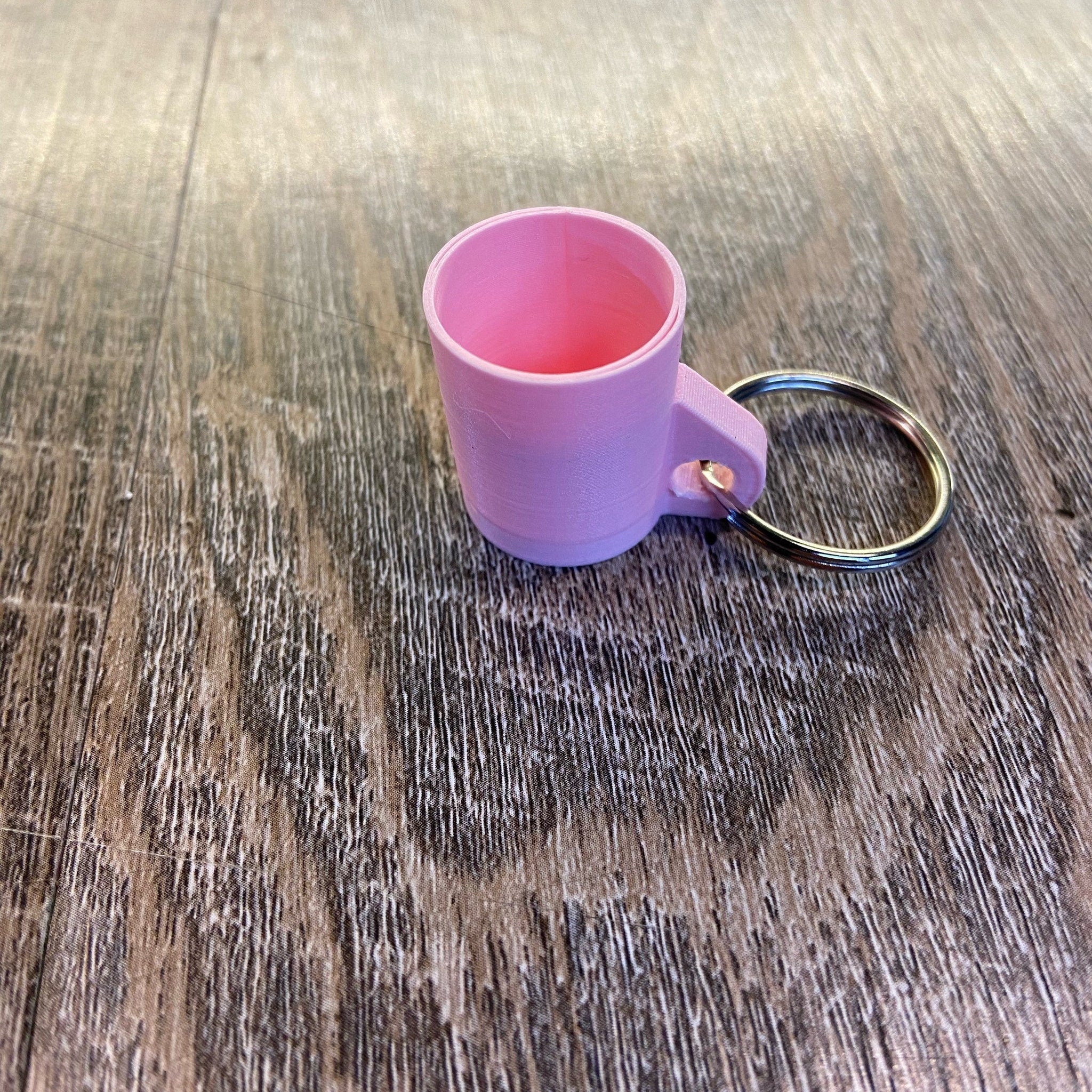 Pink keychain mug with metal ring, plastic material, and small handle detail