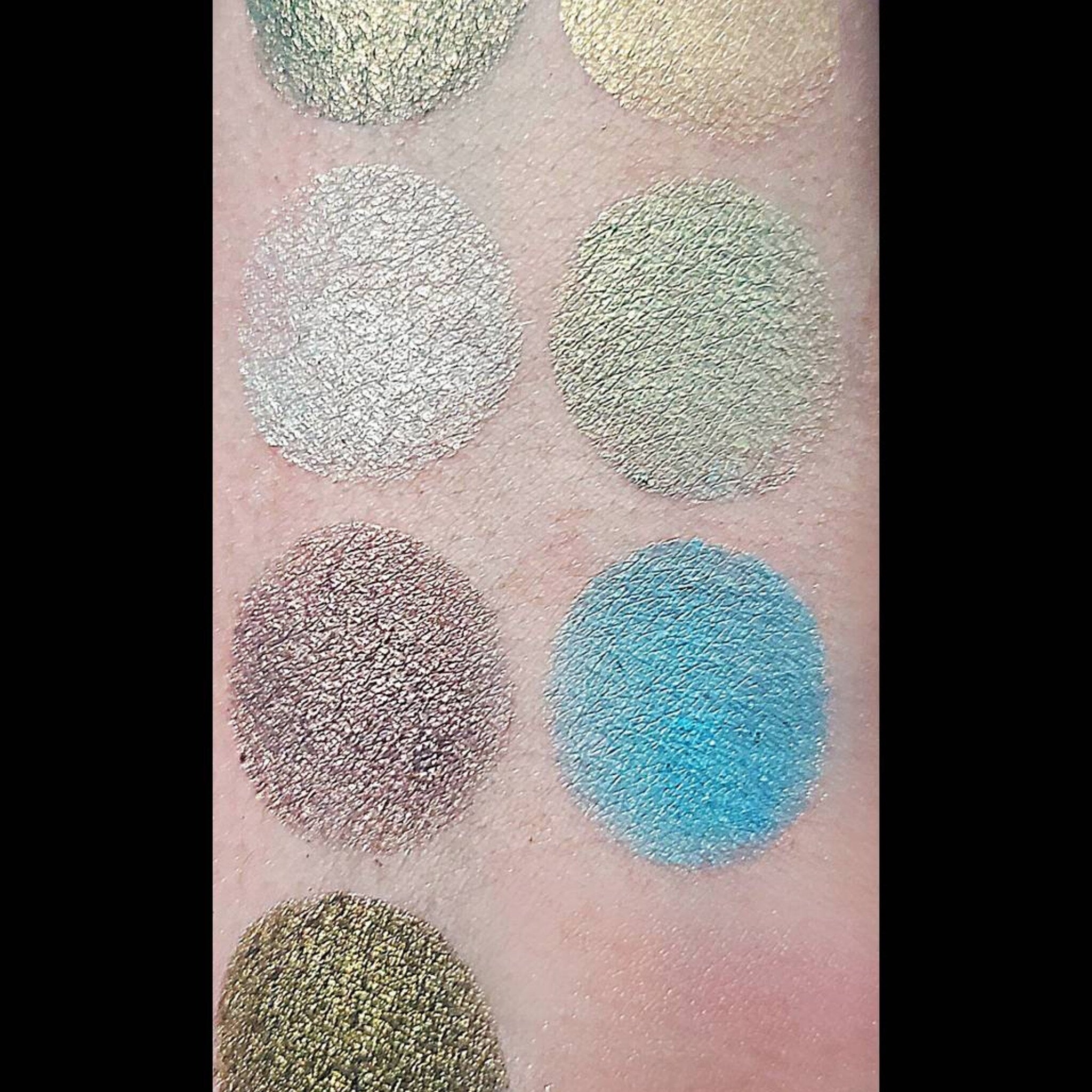Close-up of multichrome eyeshadow palette showing shifting iridescent hues from bronze to green