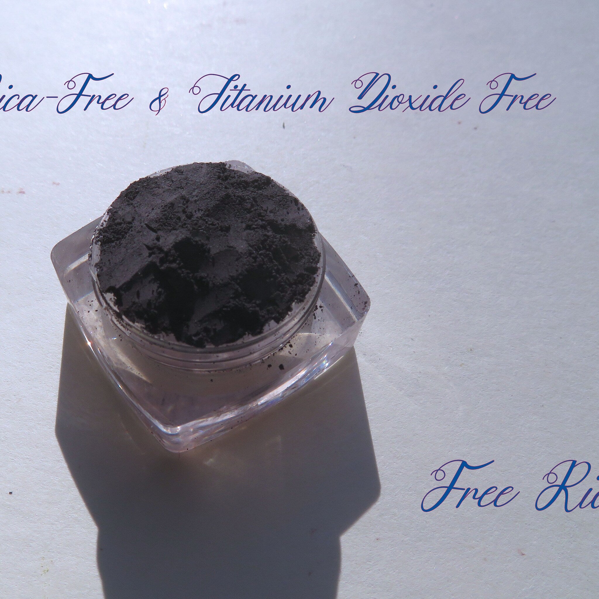 Dark powder in clear plastic container on white surface, with text "Free