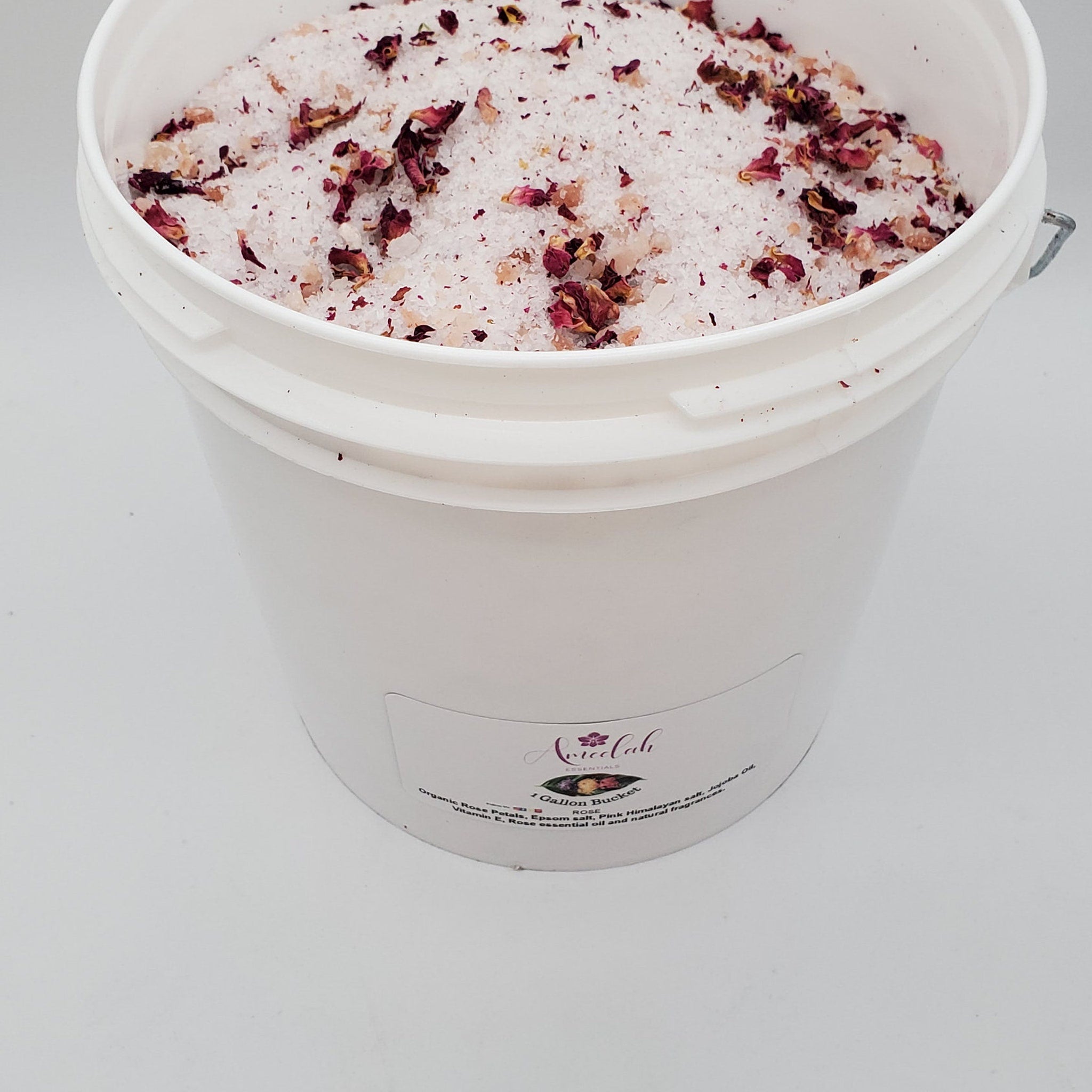 Rose bath salts with white crystals, red petals, and Ameelah Essentials label in bucket