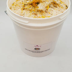 Bath salt bucket with white container, orange and yellow botanicals, Ameelah Essentials label visible