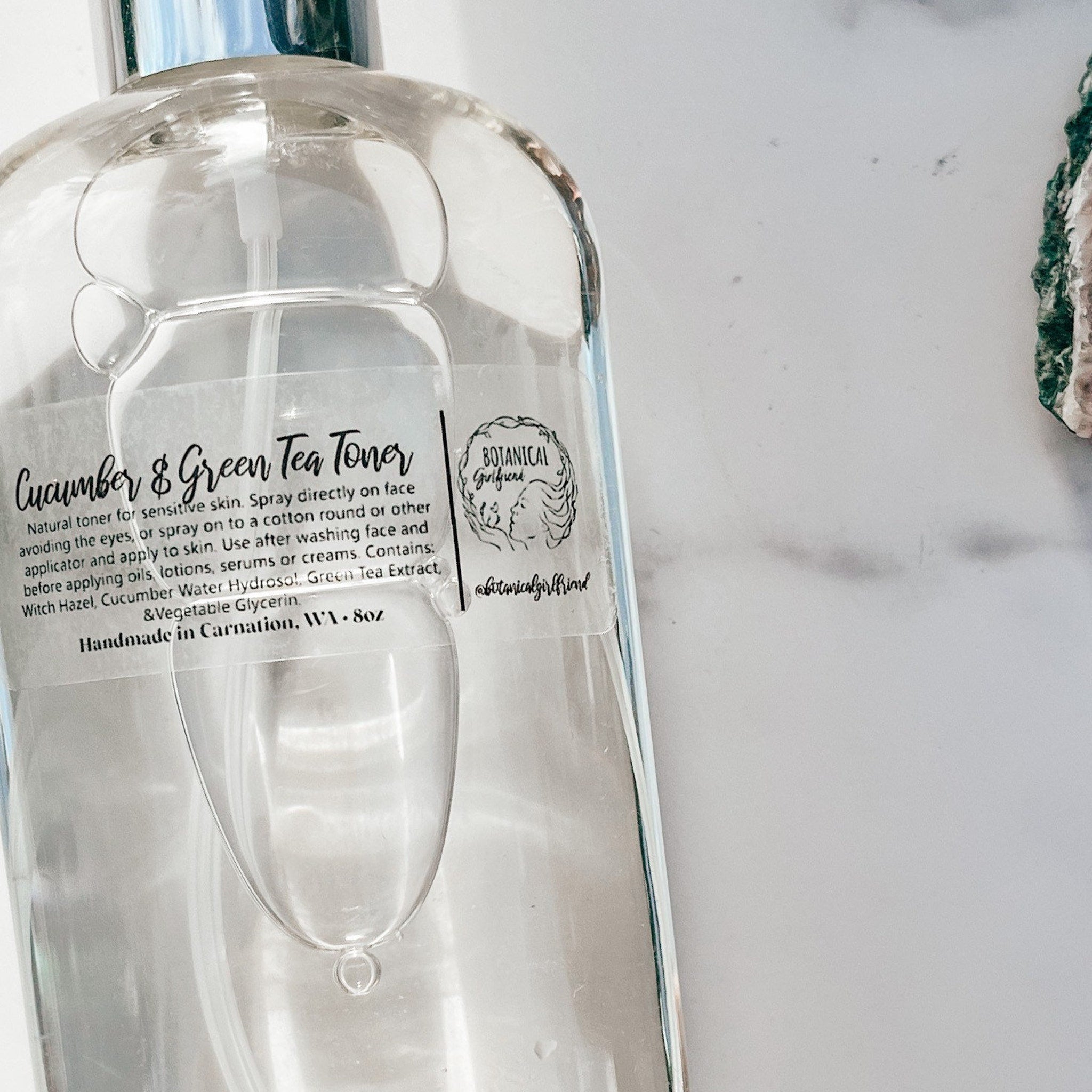 Toner bottle with clear glass, white label, and silver cap, Botanical Girlfriend label visible