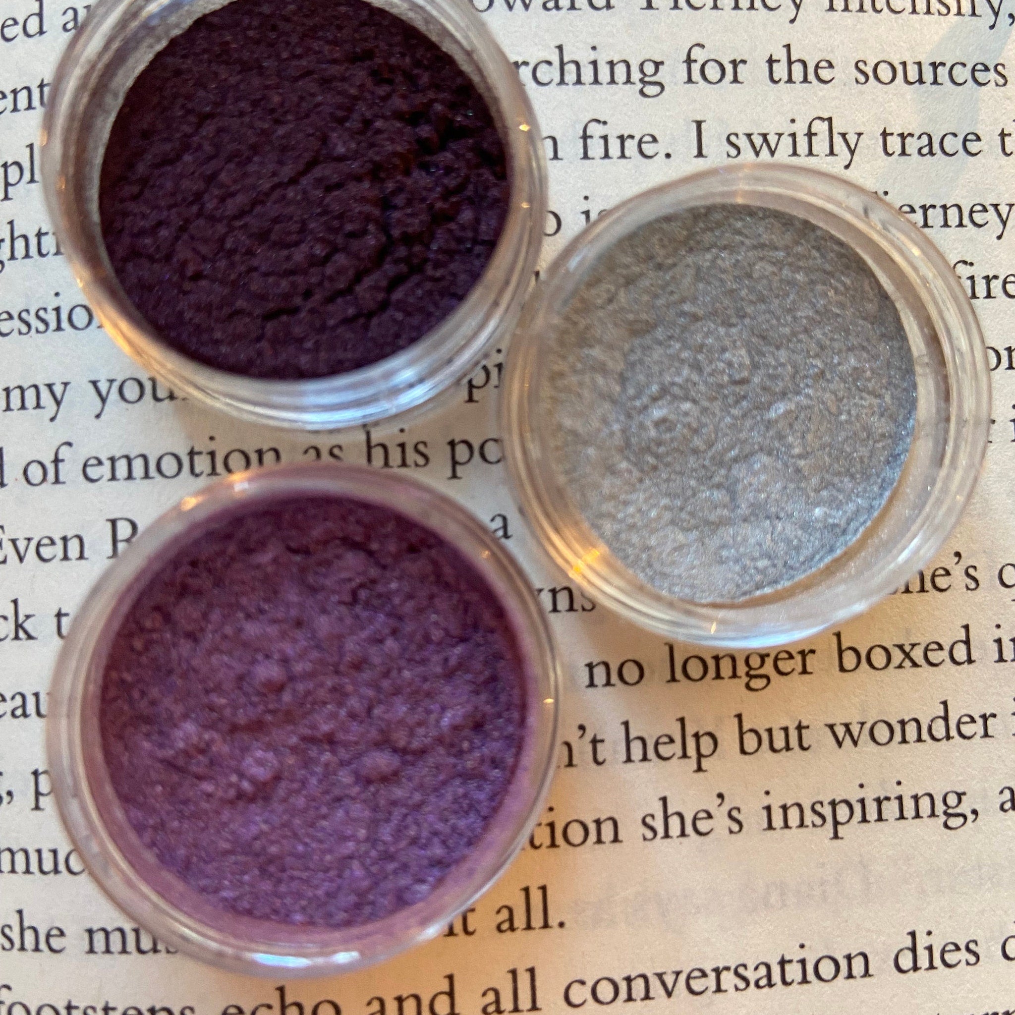 Close-up of shimmering book-shaped eyeshadow palette with rich jewel-toned shades