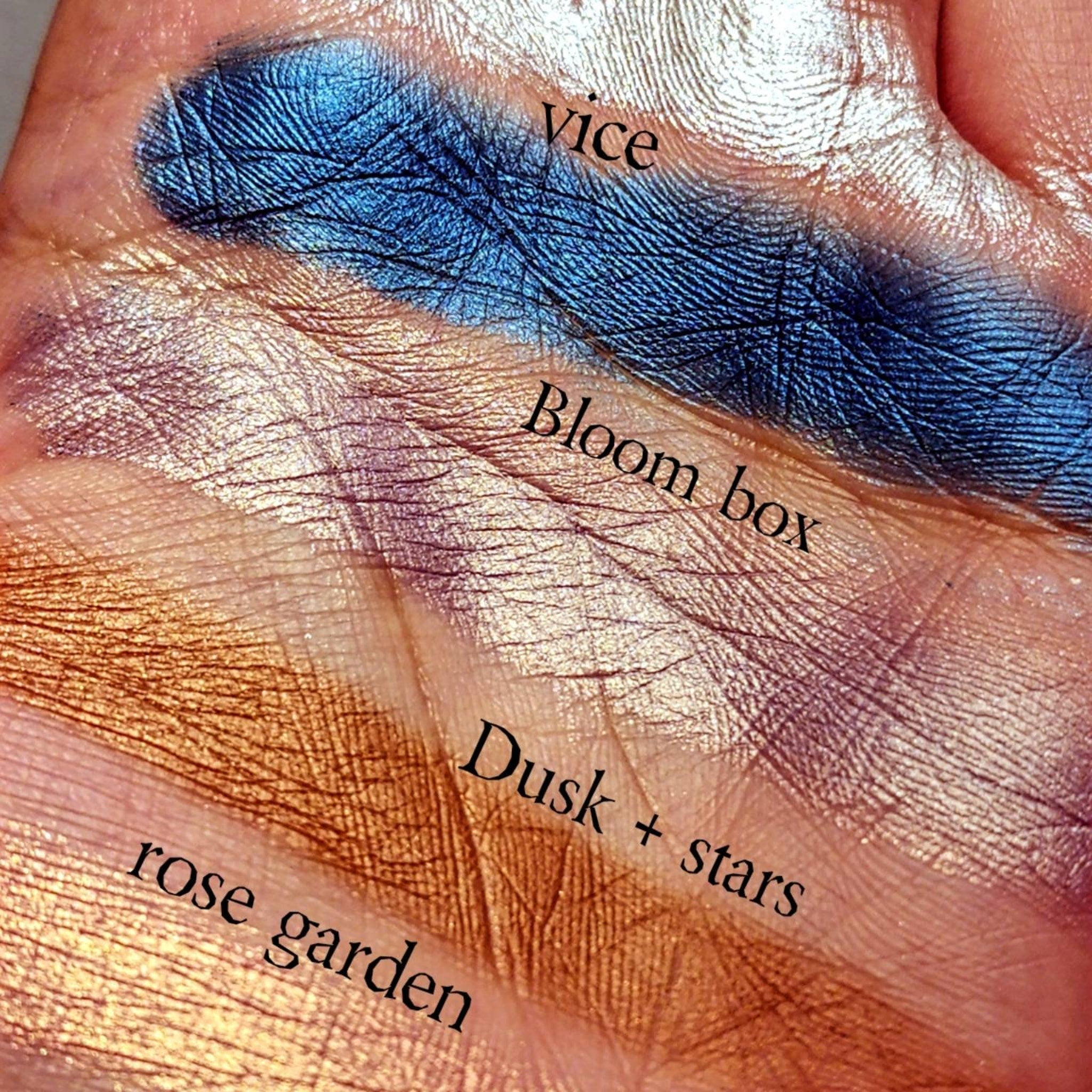 Eyeshadow swatches, metallic blue, gold, and purple shades, applied on skin, with "vice" visible text