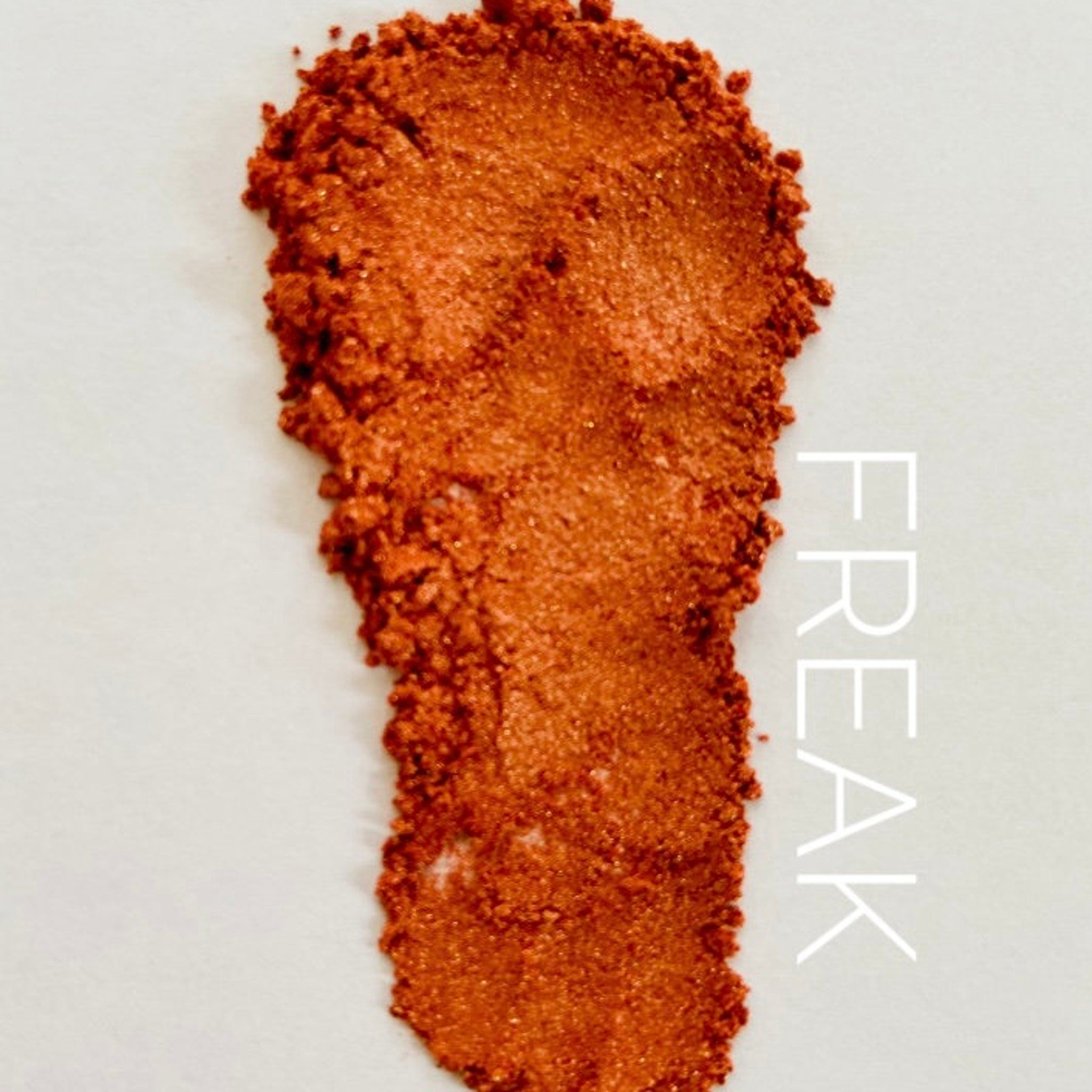 Orange metallic powder swatch with "FREAK" text on white background