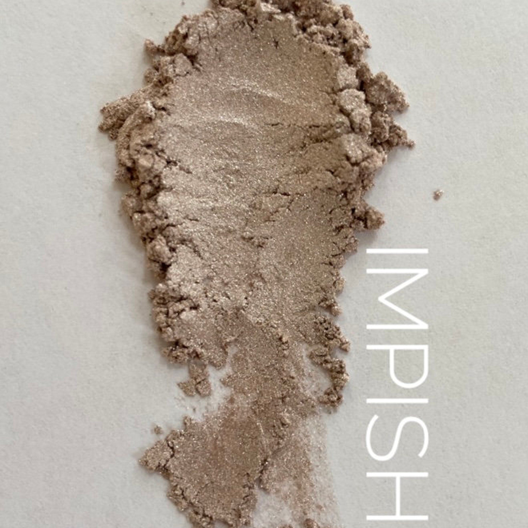 Close-up of Impish Bookish Beauty Eye Shadow palette showing shimmering bronze and plum shades with smooth, blendable texture.