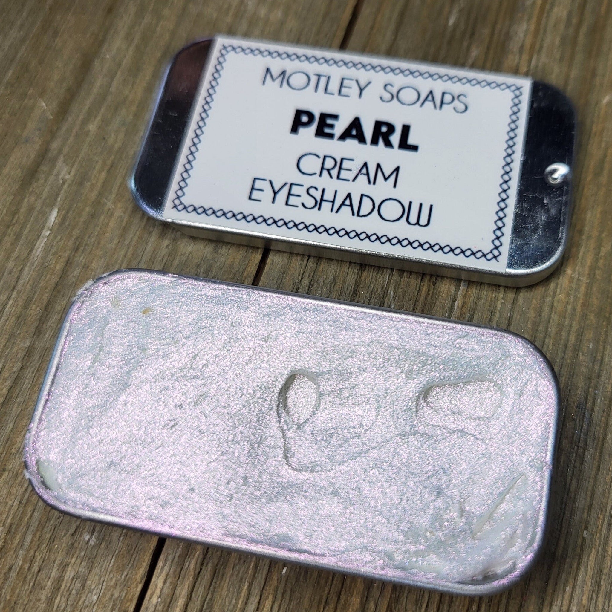 Pearlescent cream eyeshadow in a sleek silver tube with iridescent color shift effect