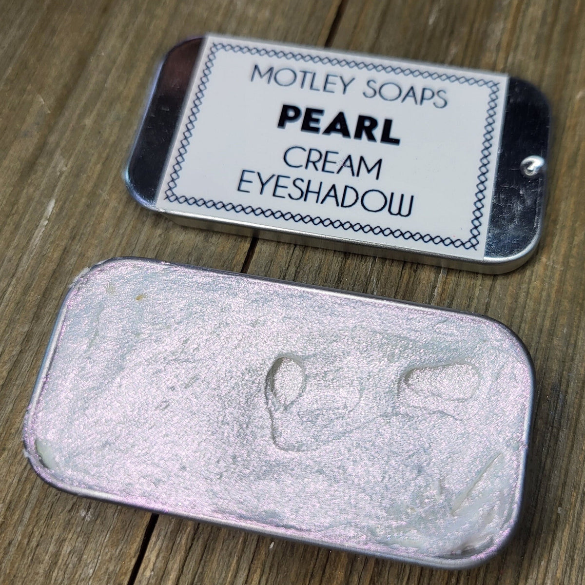 Pearlescent cream eyeshadow in a sleek silver tube with iridescent color shift effect