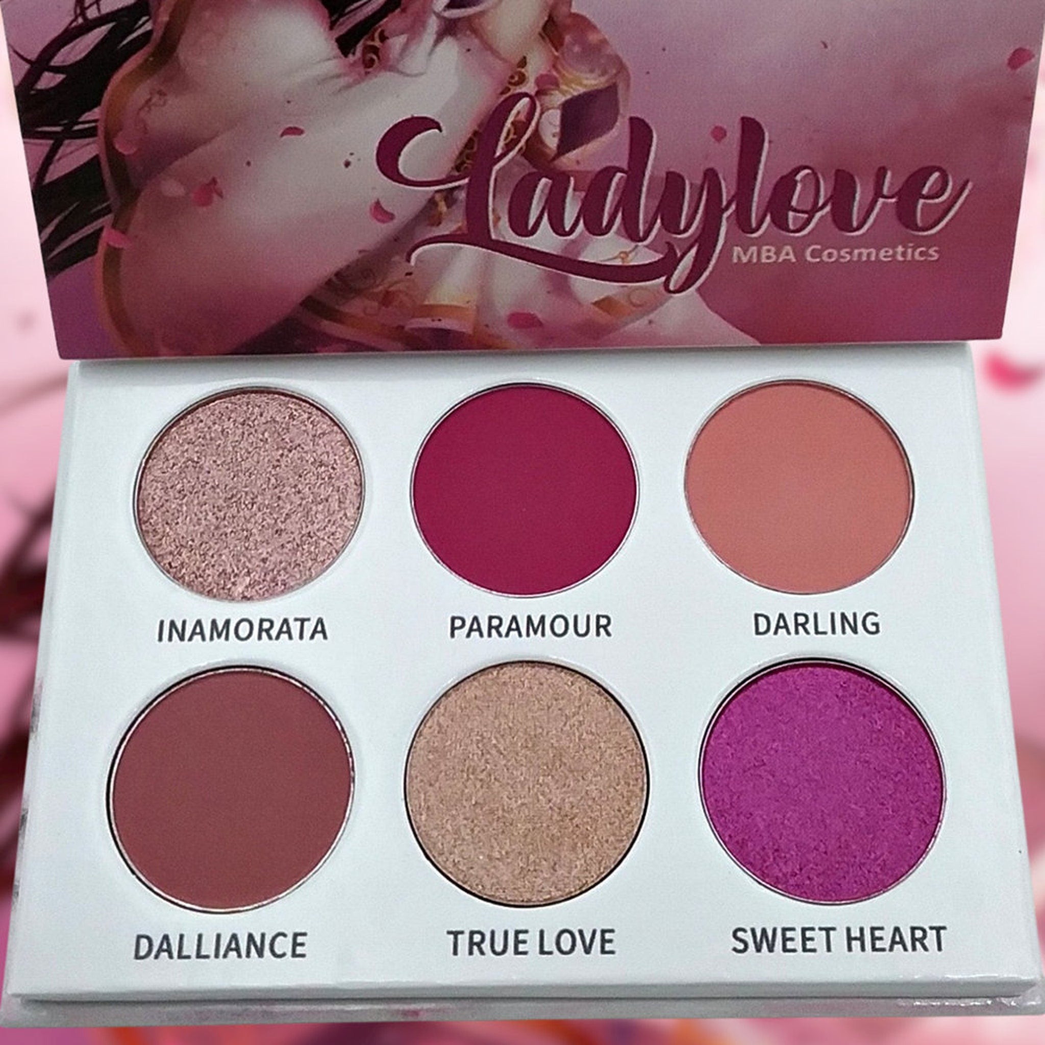 Eyeshadow palette with six round colors, pink and mauve tones, "Ladylove" brand name visible