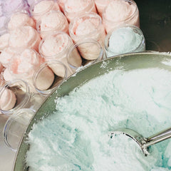 Whipped soap in jars, pink and blue colors, clear containers, and a metal bowl with a scoop.