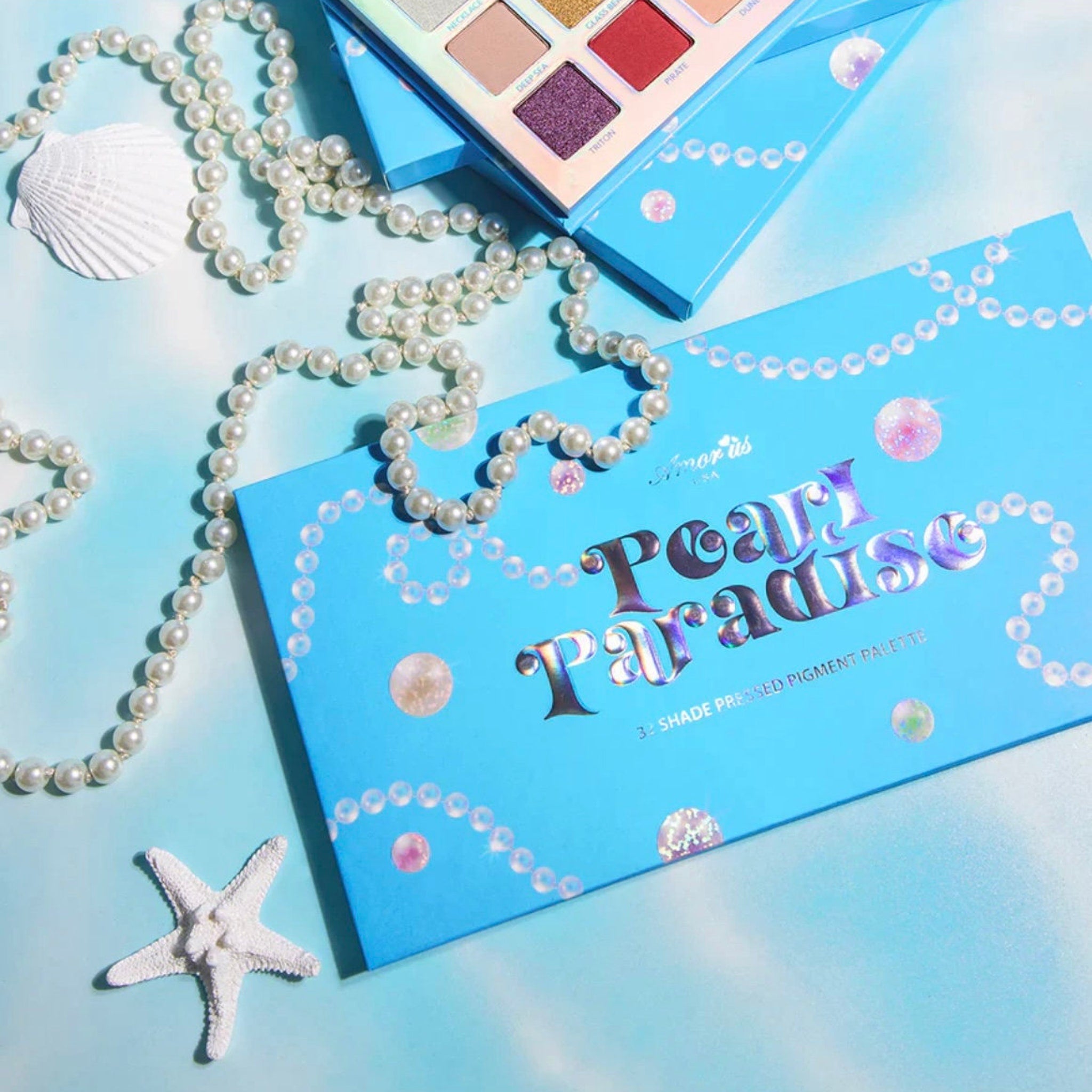 Pearl Paradise Eyeshadow Palette open with mirror, showing 12 shimmery shades in pink, gold, and bronze hues