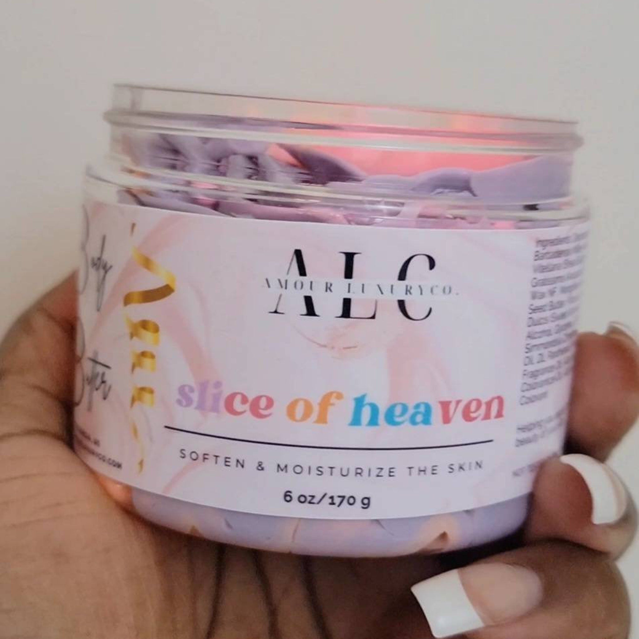 Close-up of whipped passionfruit-scented body butter in a sleek white jar, showcasing its velvety texture and golden mango swirls