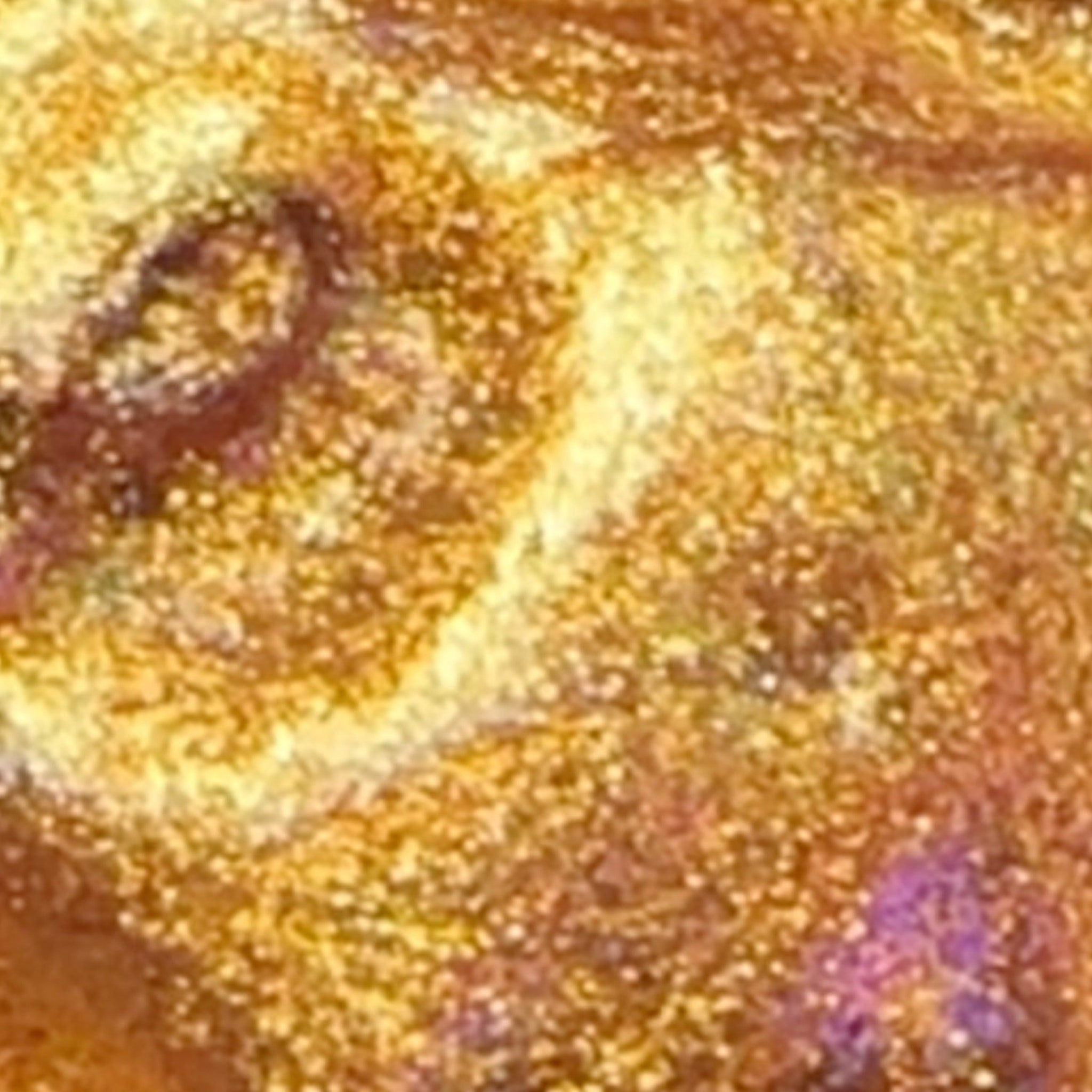 Close-up of gold glitter gel swatch on skin showing shimmer and creamy texture