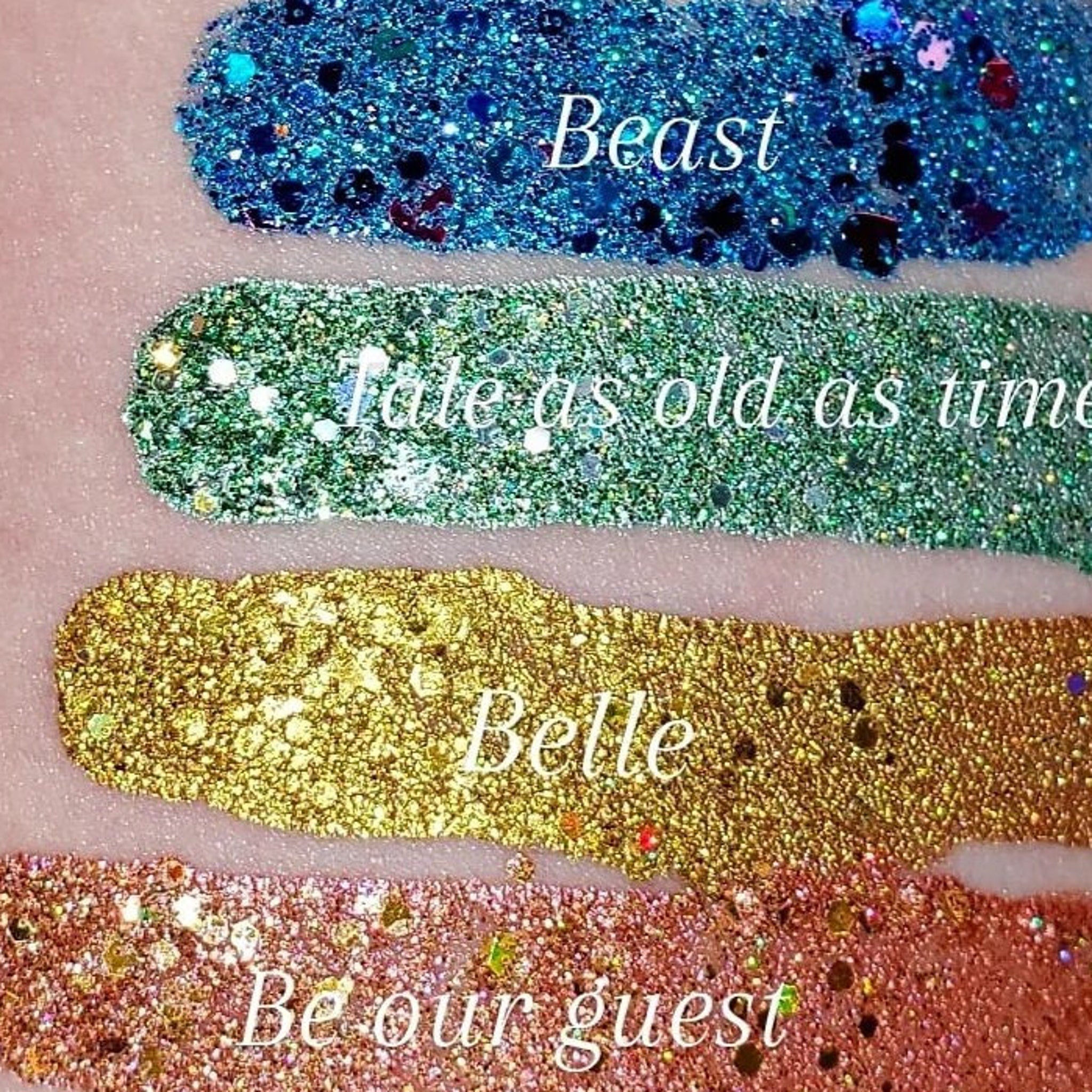 Side view of shimmering loose glitter eye shadow in a sleek transparent jar with gold lid, showcasing fine sparkle texture