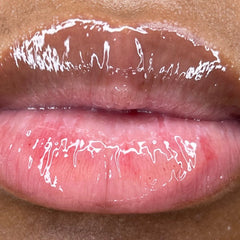 Lip gloss, glossy pink and brown lips, close-up view of a person's mouth.