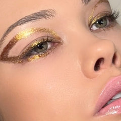 Close-up of gold glitter gel eyeshadow with aloe vera, shimmering in light for eyes, face, and body application