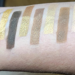 Close-up of 12 vibrant eyeshadow pans in matte and shimmer finishes, arranged in a sleek black palette