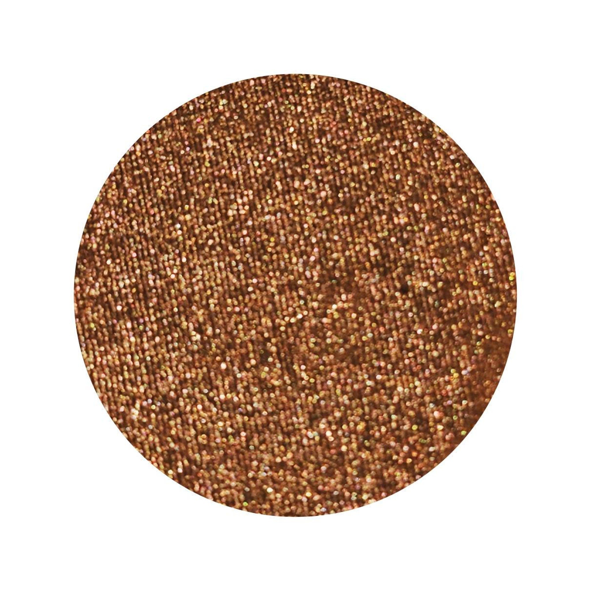 Eye shadow pan, shimmery rusty orange-brown color with gold flecks, circular shape
