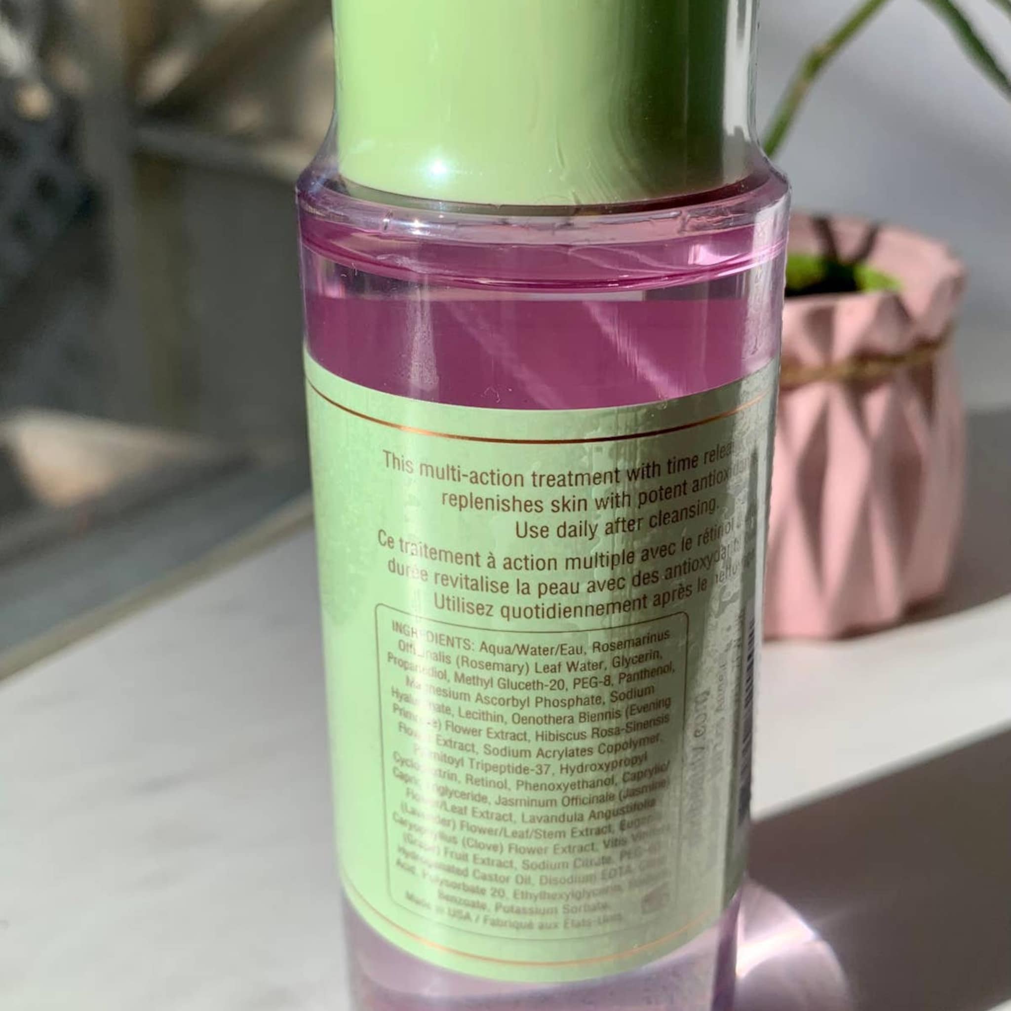 Toner bottle with pink liquid, green cap, and white label with text for daily use.