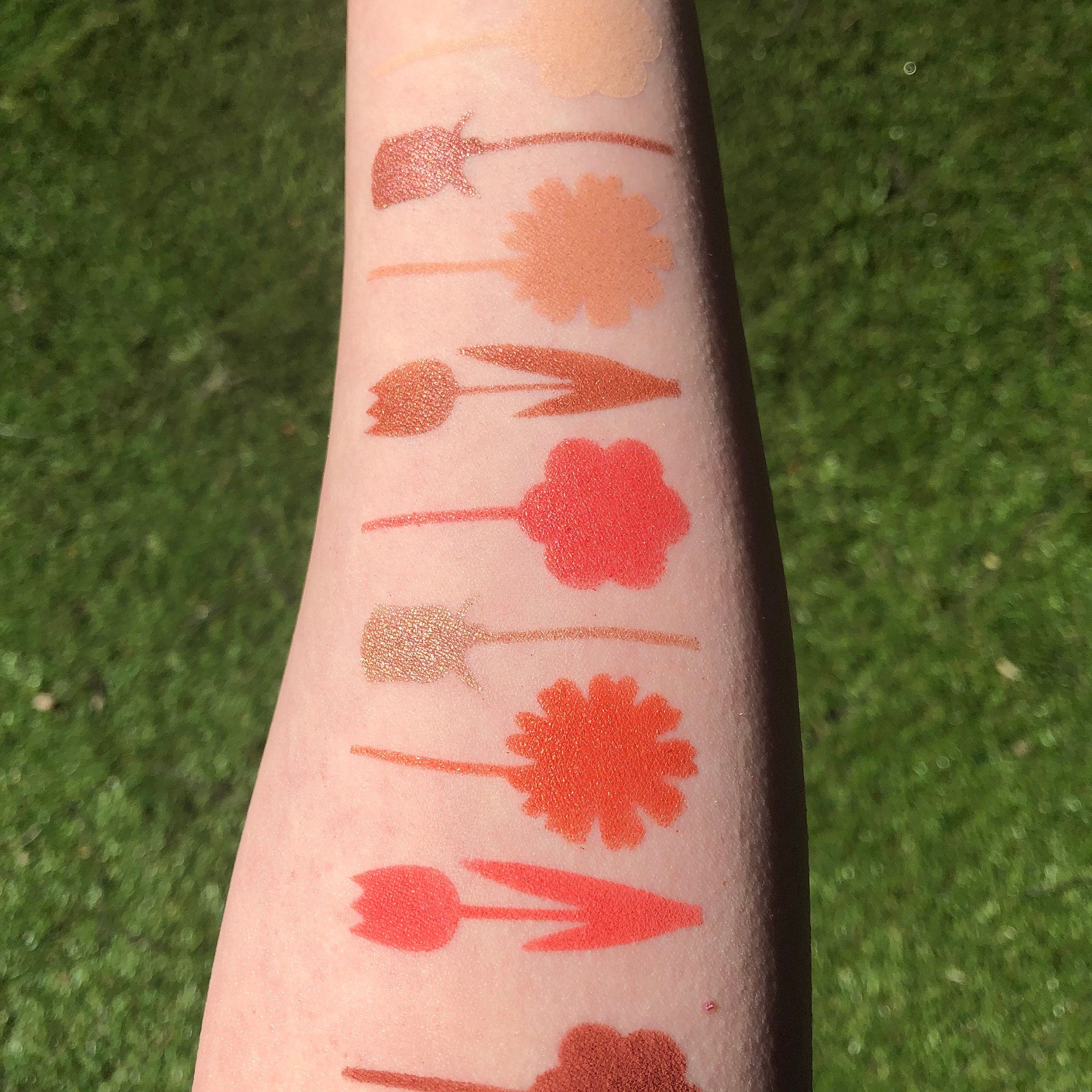Side view of Red Daisies Eye Shadow Palette showing six vibrant matte and shimmer shades in circular pans with floral imprint.
