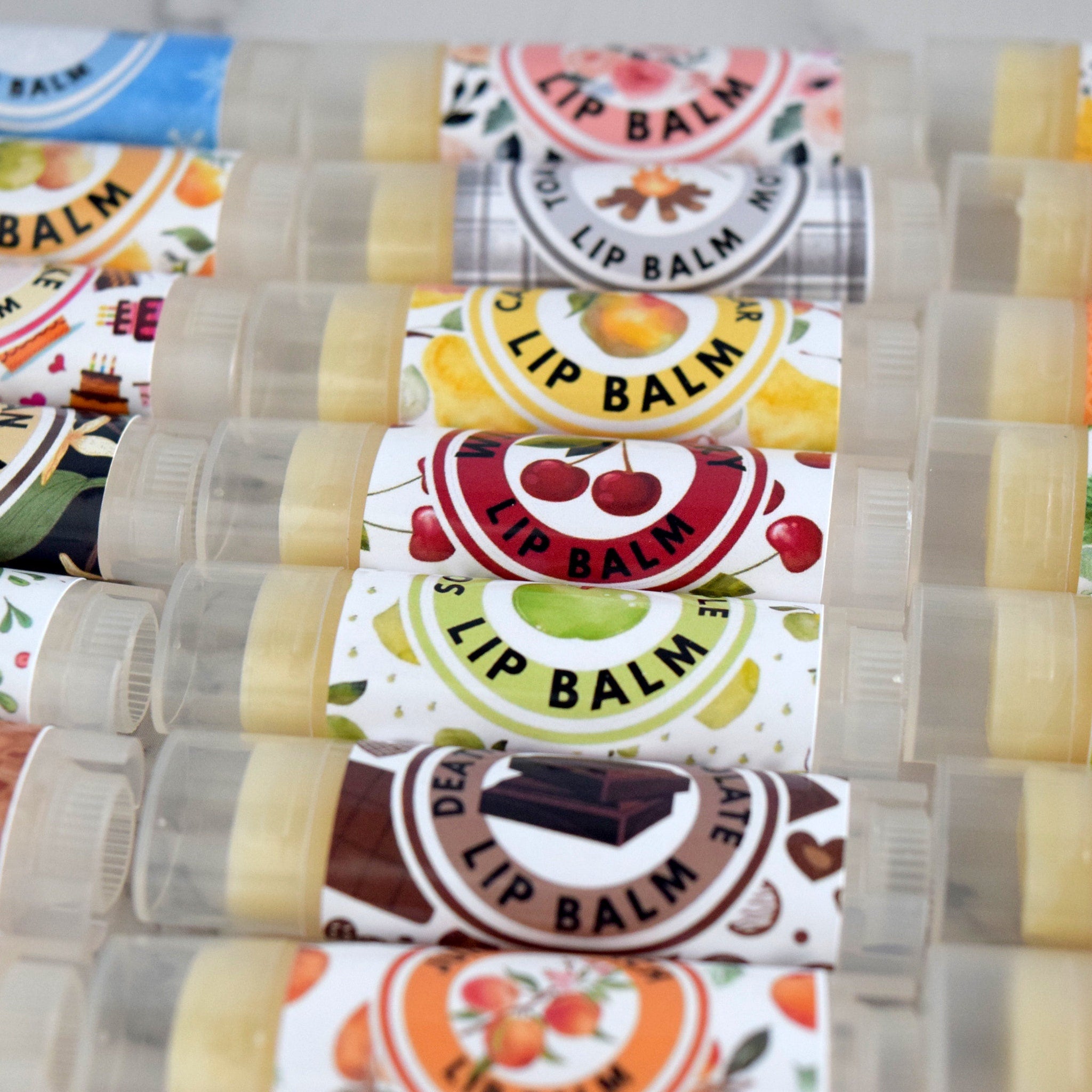 Lip balm tubes with various label designs, clear plastic casing, and visible lip balm inside