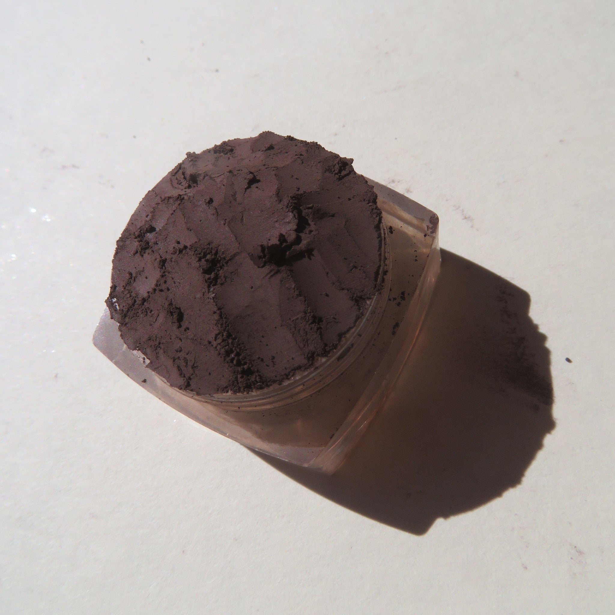 Close-up of rich mahogany brown loose mineral eyeshadow powder with velvety matte finish