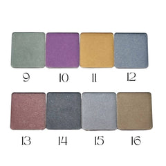 Circular refillable eyeshadow pans in matte earthy tones arranged on a wooden surface