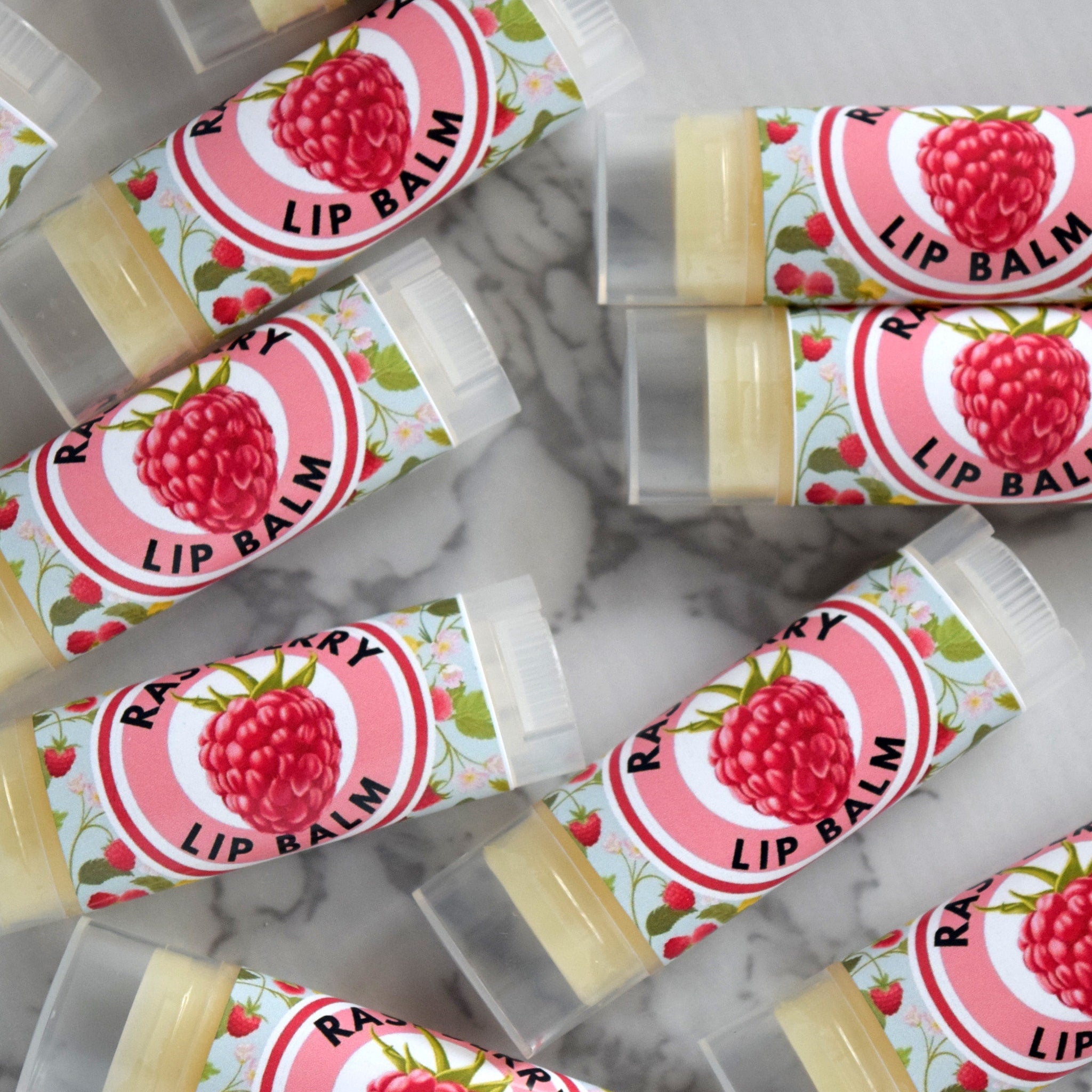 Lip balm tubes with raspberry design, clear plastic, and floral pattern, ready to use