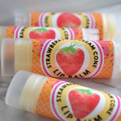 Lip balm tubes with strawberry labels, orange waffle cone pattern, and clear caps