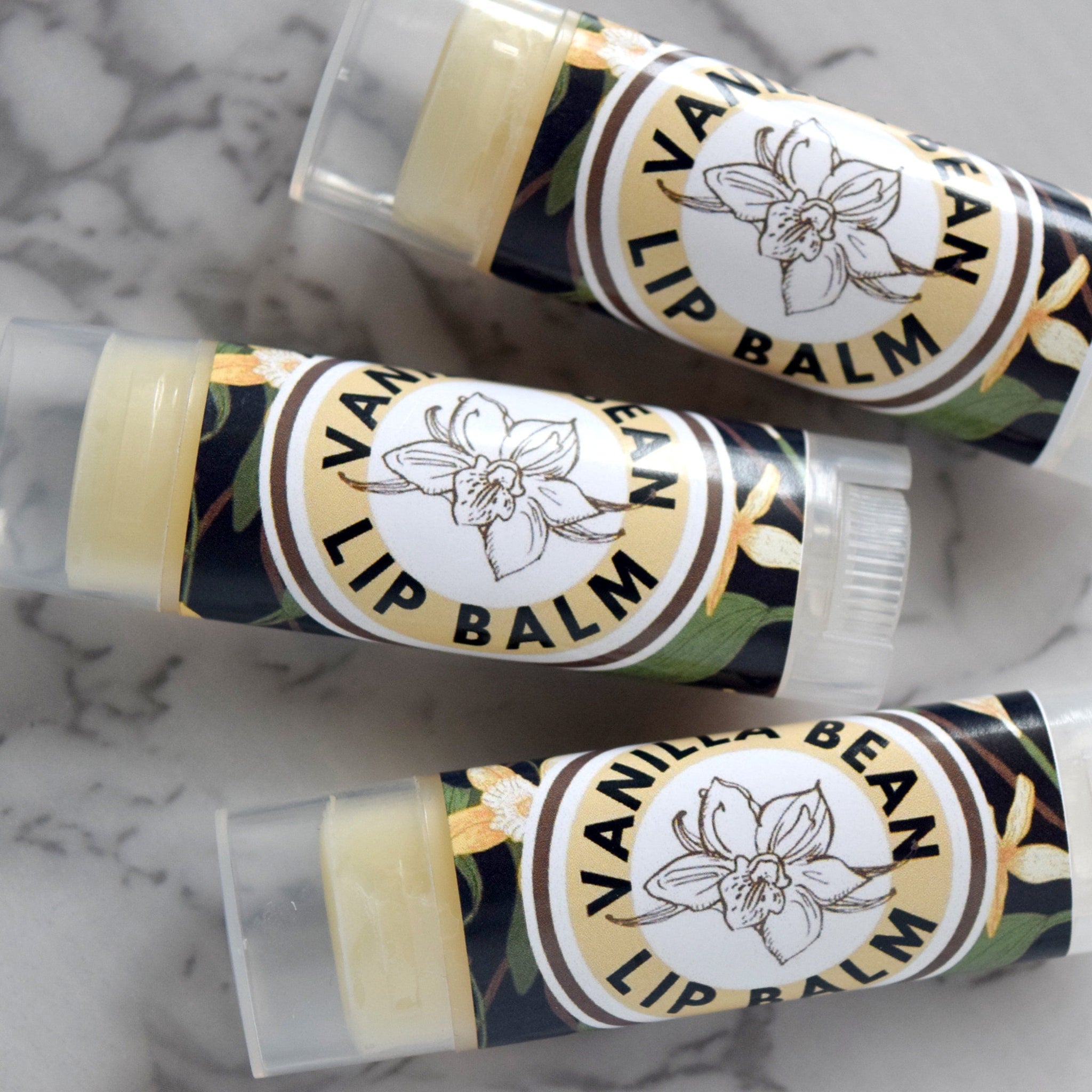 Lip balm tubes with "Vanilla Bean Lip Balm" label, clear plastic, and light yellow balm inside