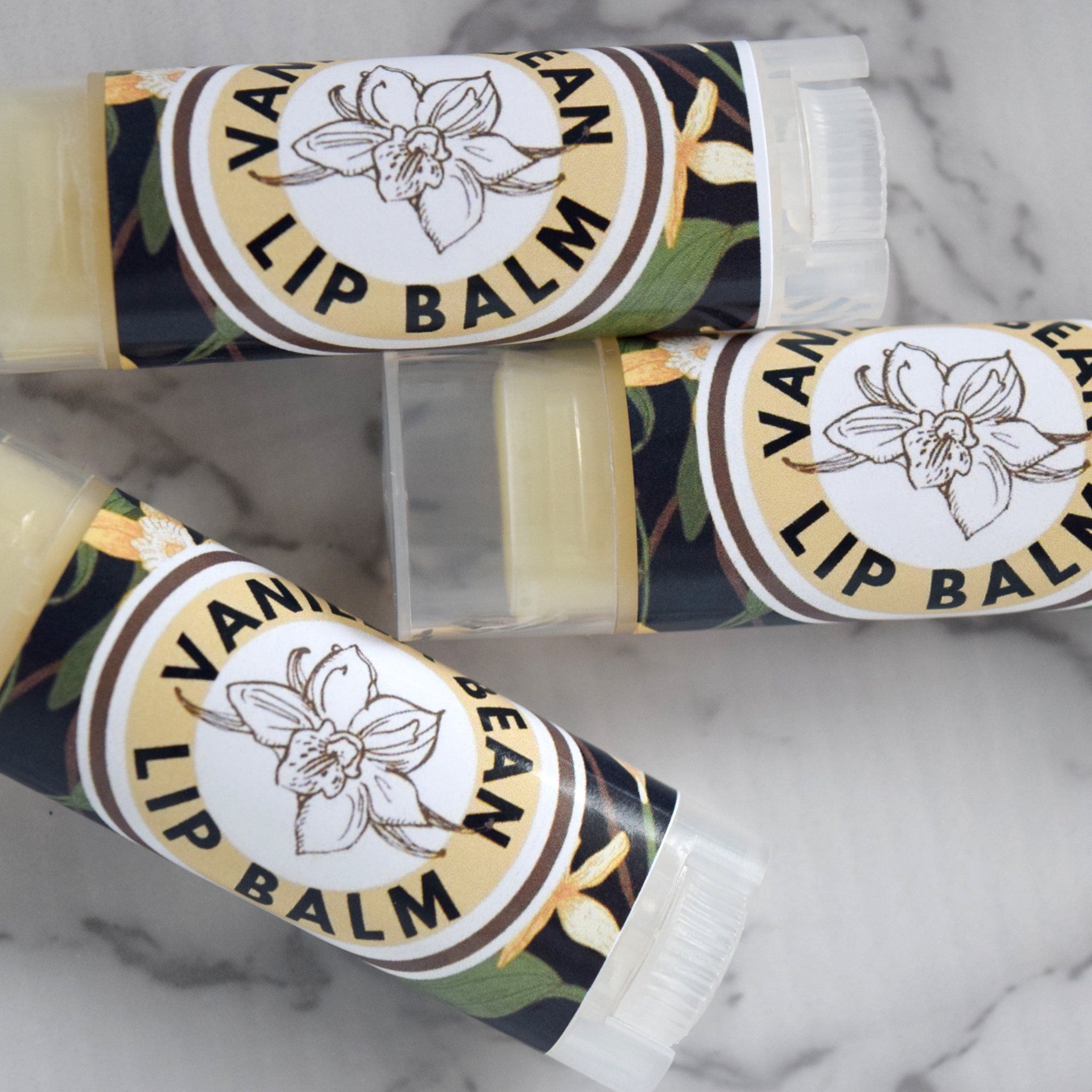 Lip balm tubes with "Vanilla Bean Lip Balm" labels, clear plastic, and floral pattern