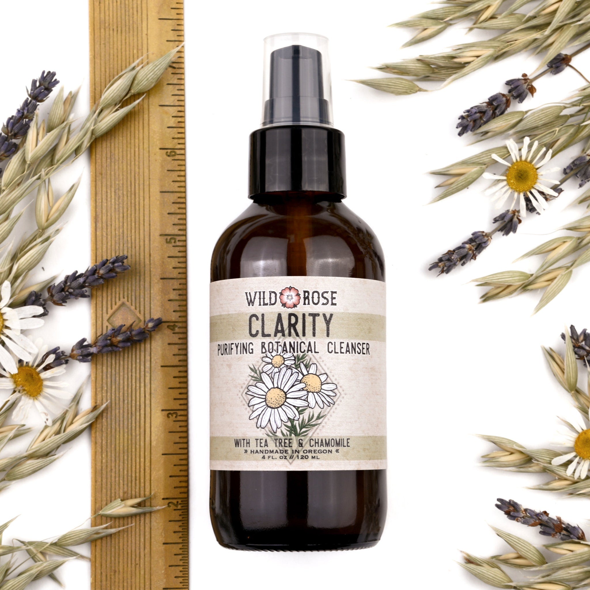 Brown glass bottle with Wild Rose label and botanical accents on white background