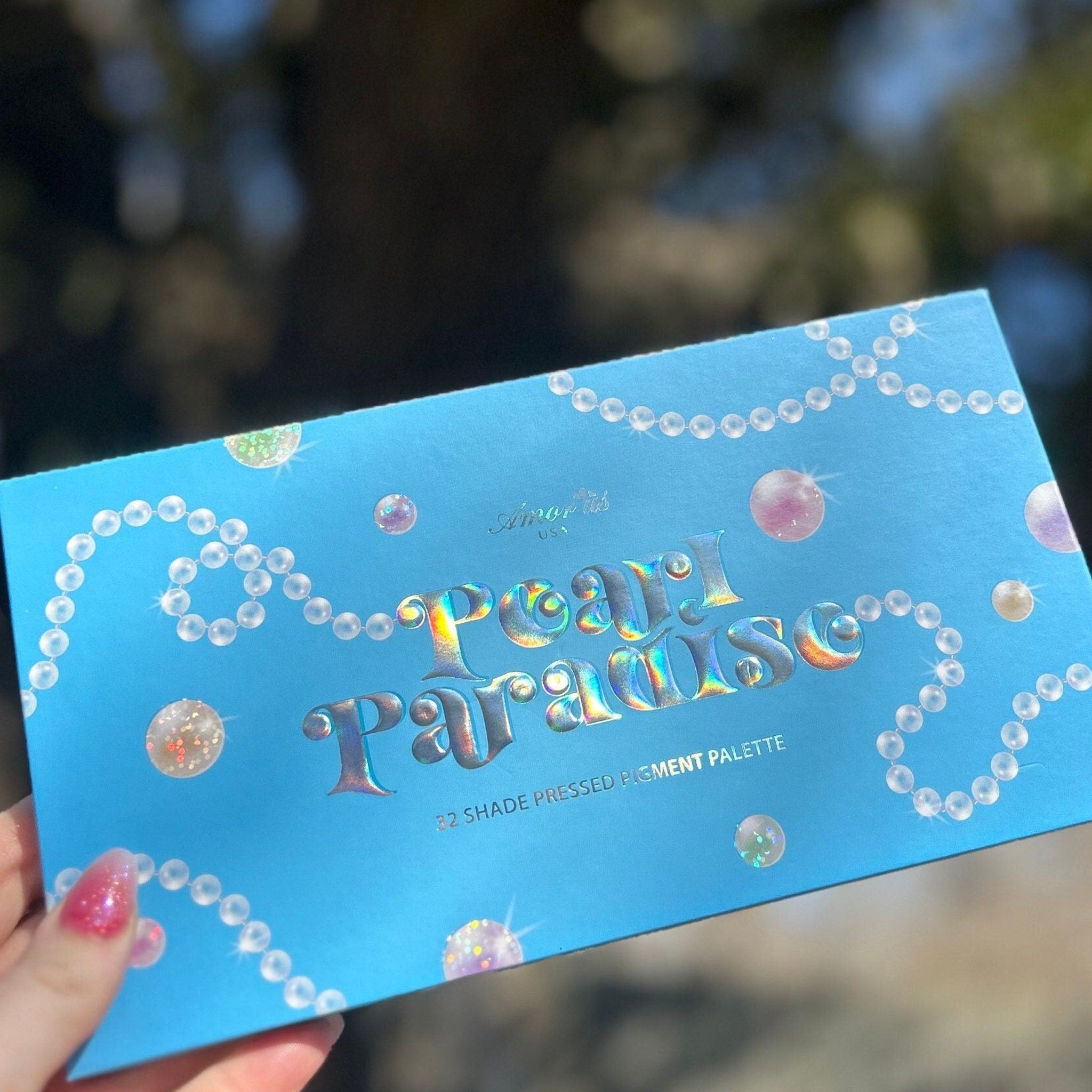 Pearl Paradise Eyeshadow Palette open with 12 shimmer shades in pink, gold, and bronze tones