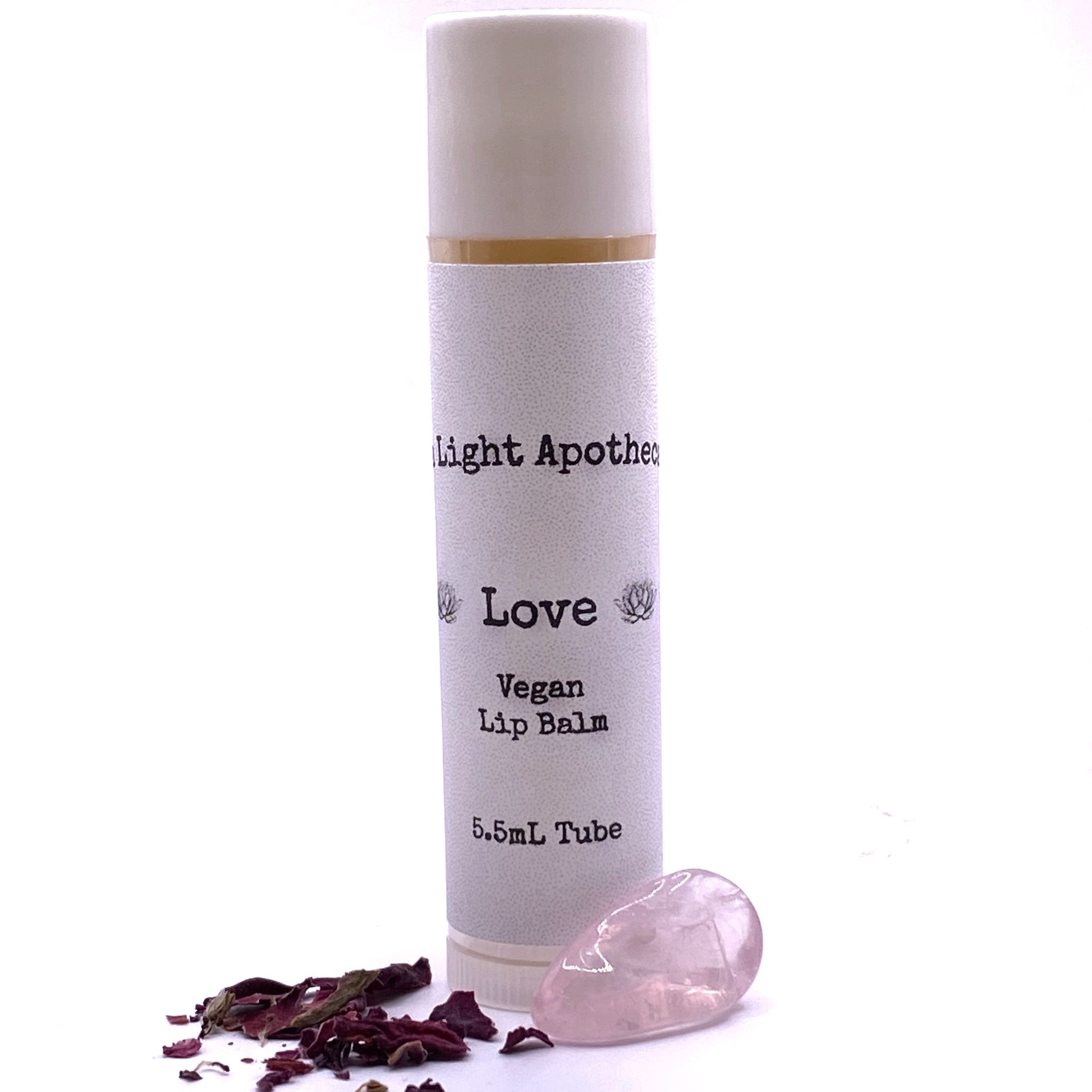 Lip balm tube with white textured label, gold band, and Aura Light Apothecary branding