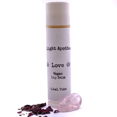 Lip balm tube with white textured label, gold band, and Aura Light Apothecary branding