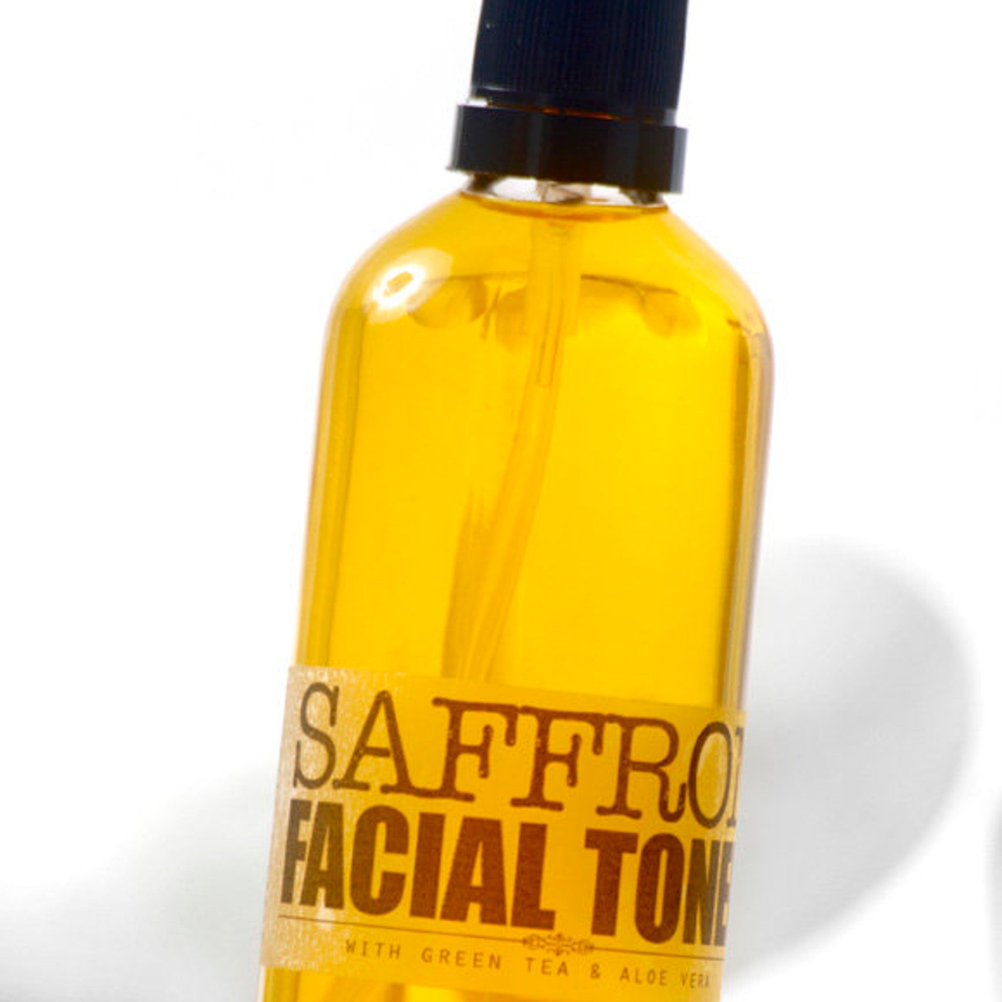 Facial toner bottle with yellow liquid, black cap, and brown label with text