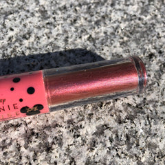 Close-up of Minnie Mouse metallic pink liquid eyeshadow with shimmer finish in sleek tube