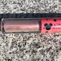 Side view of Minnie Mouse metallic pink liquid eyeshadow bottle showing shimmer finish and applicator wand