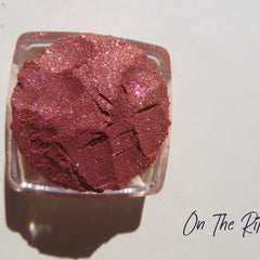 Shimmering loose mineral eyeshadow in orange-pink-gold tones with vegan, carmine-free formula in a small jar