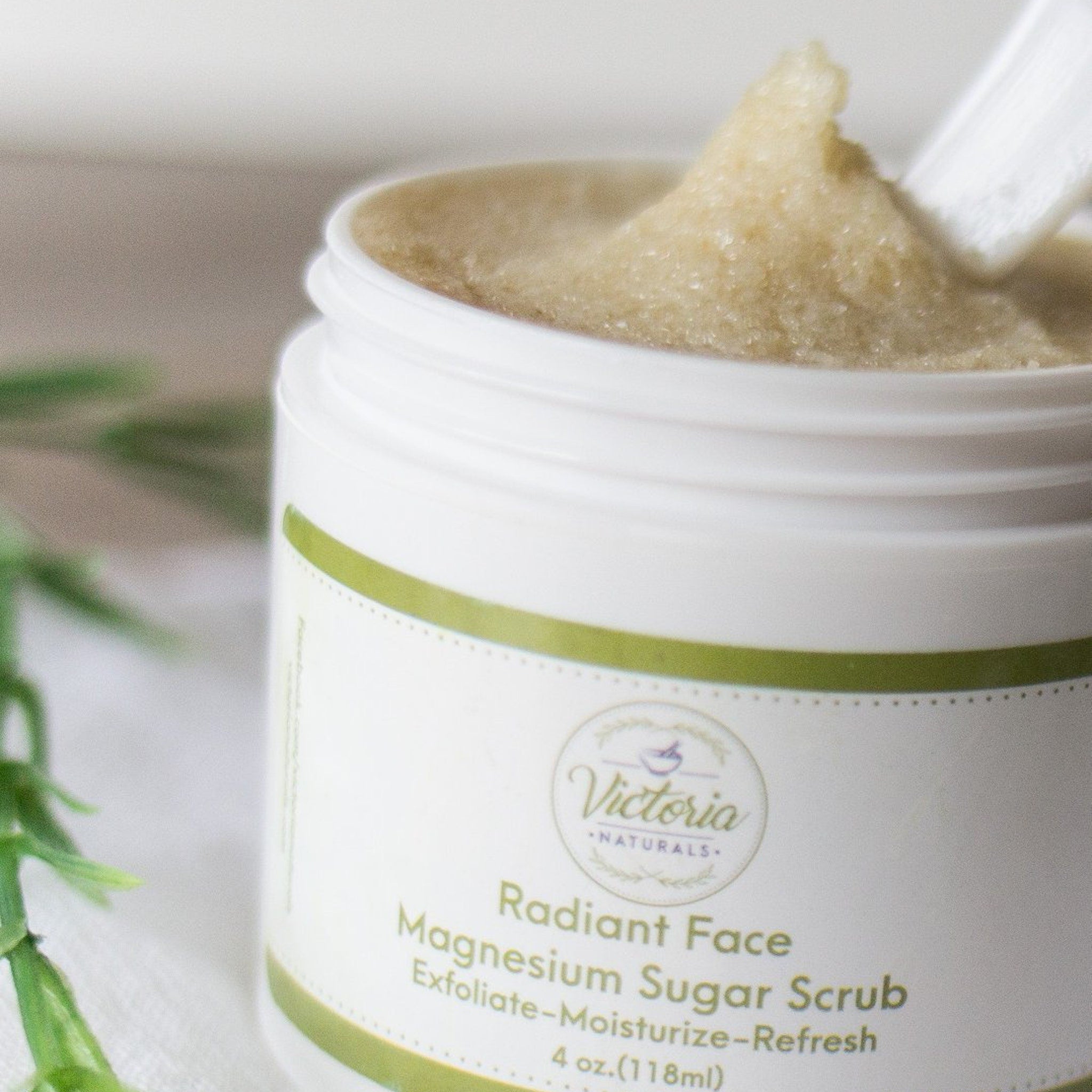 Magnesium sugar scrub in white jar with green label, grainy texture, Victoria Naturals brand