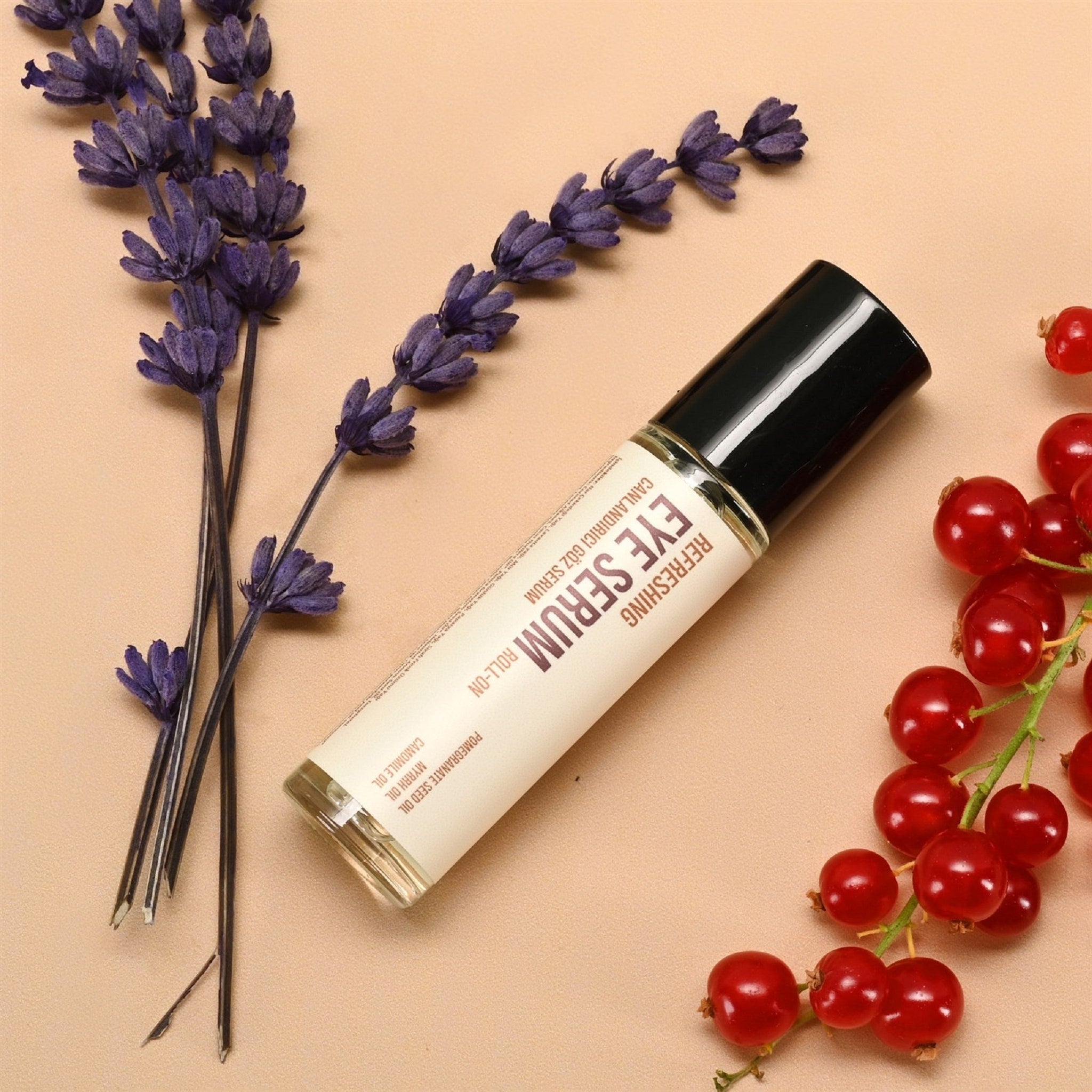 Eye serum roll-on bottle with black cap, beige label, and purple lavender sprigs on beige background