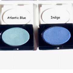 Eyeshadow compacts with blue and indigo shades, Avon brand text visible