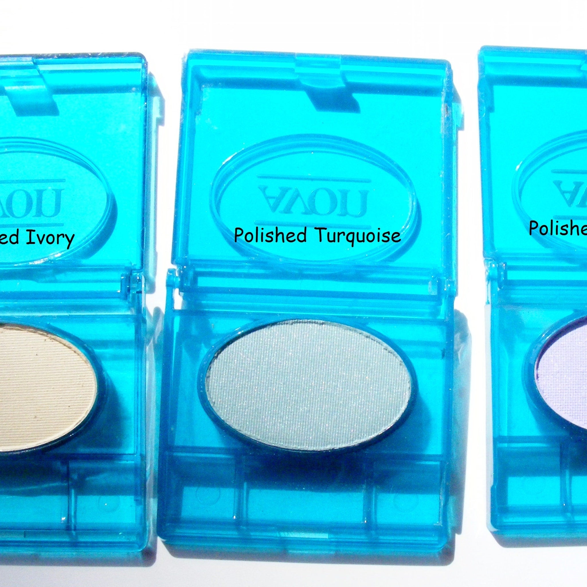 Close-up of fingertips applying creamy powder eyeshadow in a soft taupe shade to eyelid