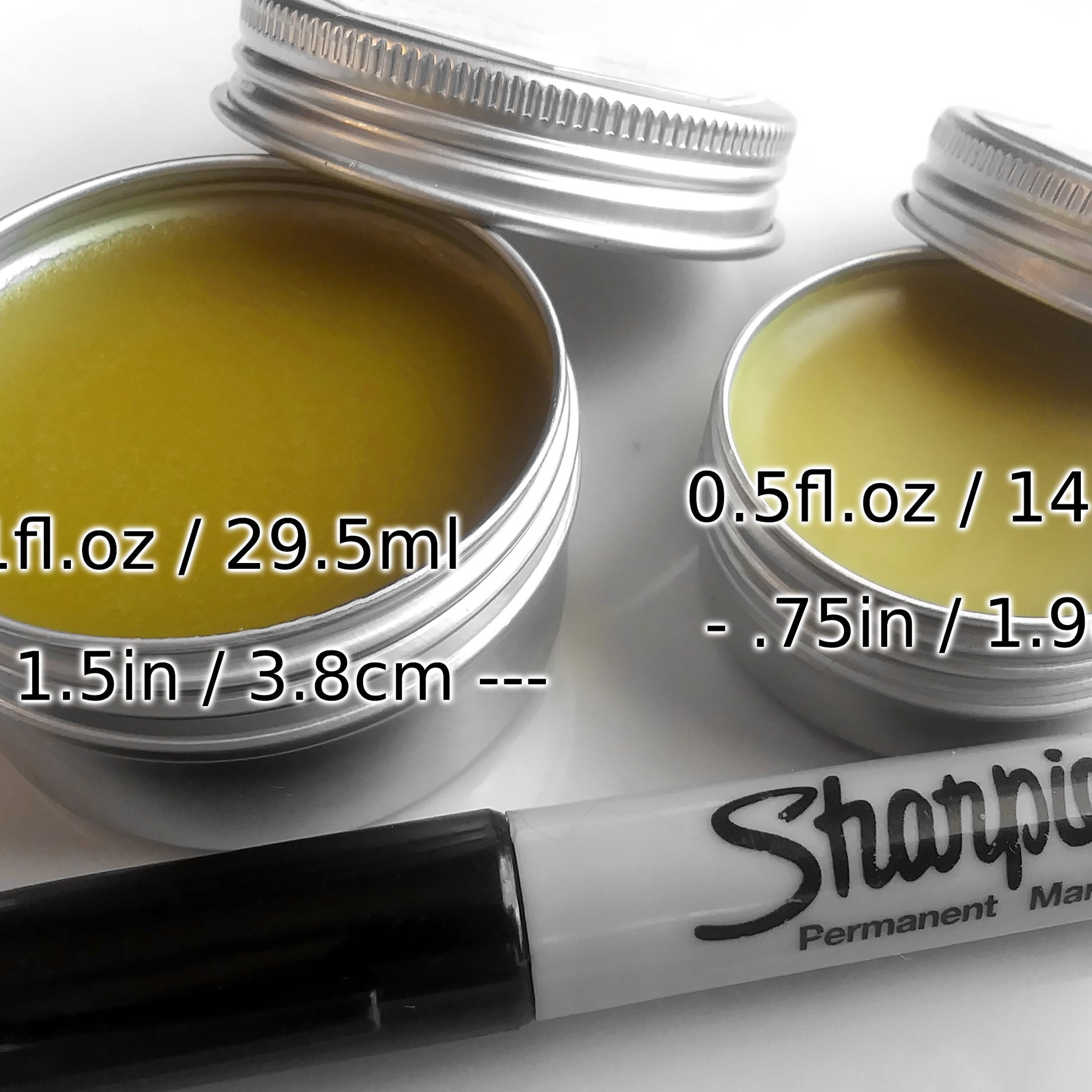 Metal tins with yellow contents, silver lids, and Sharpie marker for scale