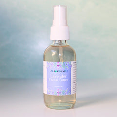 Lavender facial toner bottle with white spray top, clear glass, and floral label from JM Botanicals