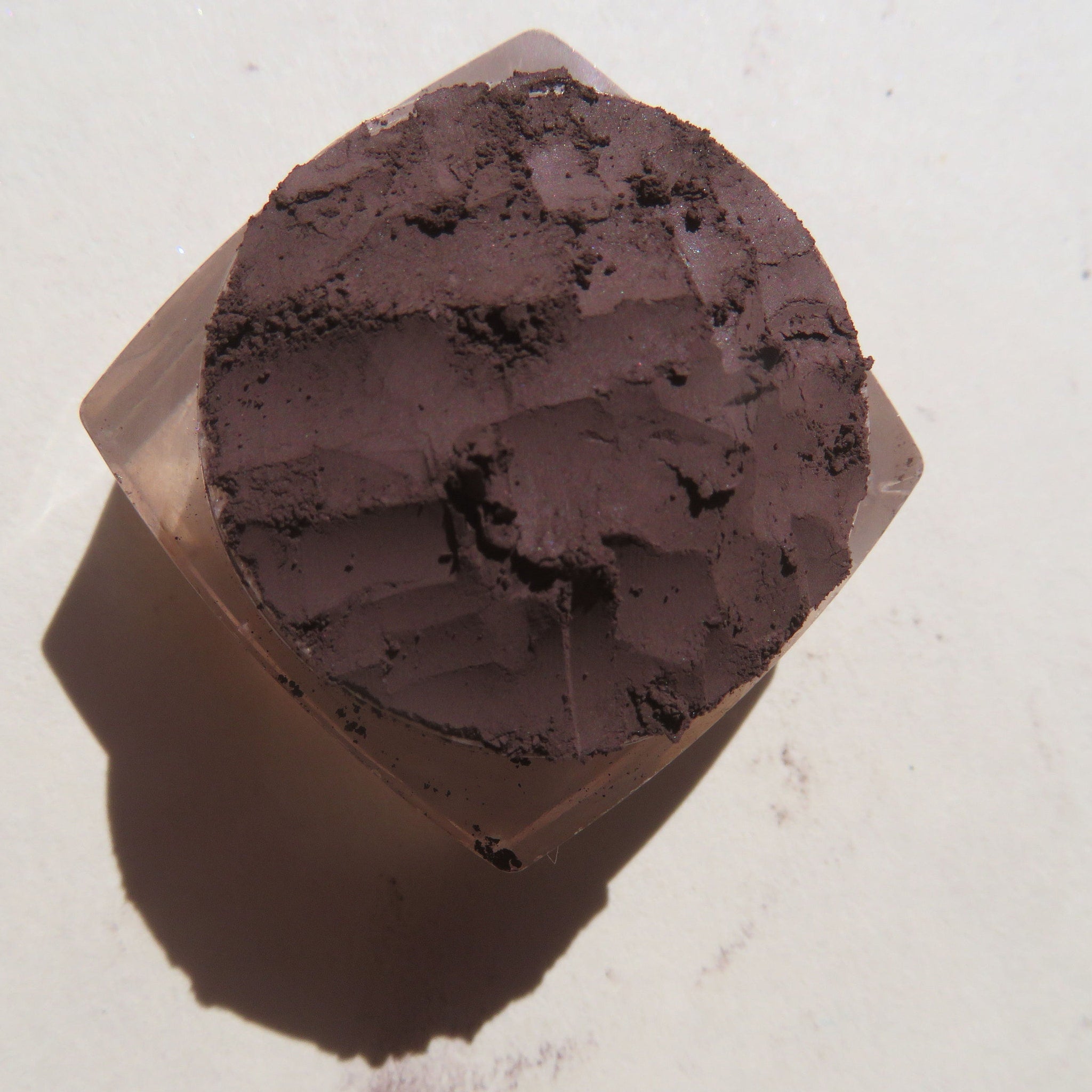 Side view of rich mahogany loose mineral eyeshadow powder in dark brown vegan pigment with matte finish