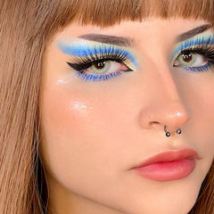 Hand applying multichrome eyeshadow with fingertip, showing vibrant color shift on eyelid
