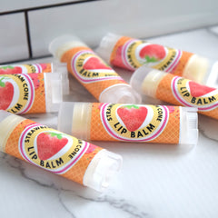 Lip balm tubes with strawberry design, orange waffle cone pattern, and clear caps